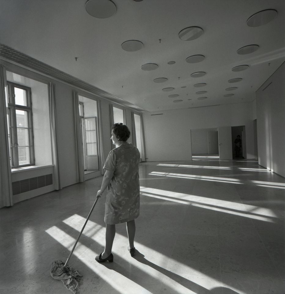 Uusittu kaupungintalo. Siistijä siivoaa tyhjää tilaa, 1970