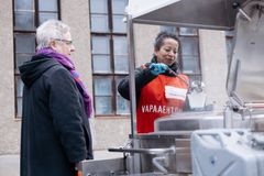 En Röda Korsets frivillig serverar mat till en person utomhus.