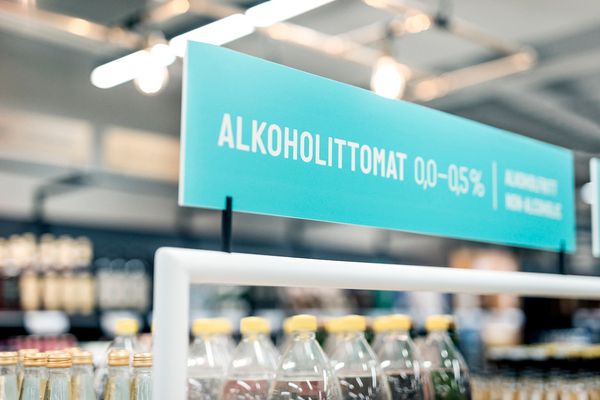 Kuva Alkon myymälän opastekyltti, jossa korostetaan alkoholittomien tuotteiden hyllyä.