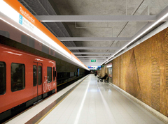 Rautatientorin metroaseman havainnekuvassa metrojuna on asemalla ja laiturilla istuu henkilö.