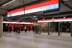 Rautatientorin metroaseman laiturilla uudet opasteet, matkustajat menossa saapuneen metrojunan kyytiin.