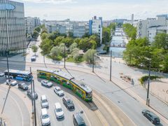 Raitiovaunu ja bussi sekä henkilöautoja kuvattuna yläviistosta ilmakuvana.