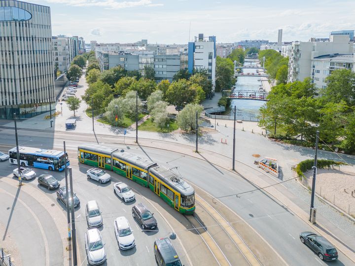 Raitiovaunu ja bussi sekä henkilöautoja kuvattuna yläviistosta ilmakuvana.