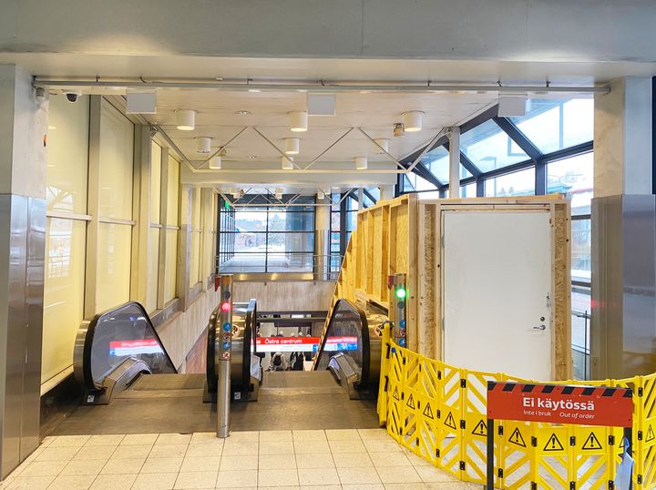 Liukuportaiden yläpää ja vaneriset työmaasuojaukset.