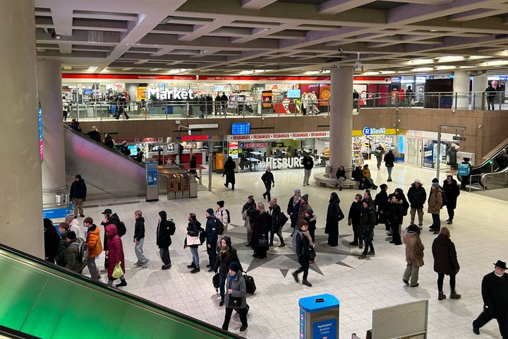 Rautatientorin metroaseman lippuhalli, useita ihmisiä kävelee kompassitasolla. Taustalla liiketiloja ja portaat.