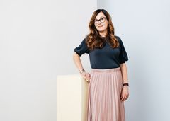 Tummahiuksinen nainen hame päällään.