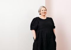 Vaaleahiuksinen nainen mekossa.