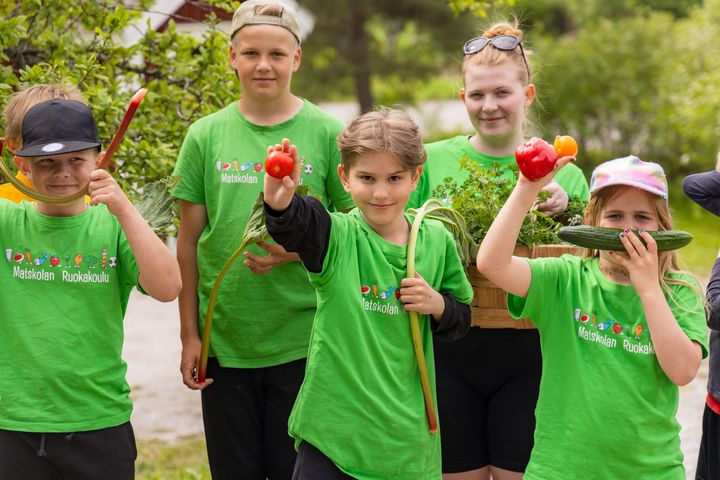 Kuva: Lapset pitävät esillä vihanneksia Nuorisojärjestö 4H:n Ruokakoulu-leirillä, jossa he valmistavat itse päivän ateriat.