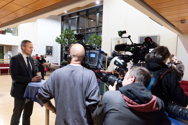 Journalists interviewing a man.