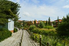 The verdant setting is surrounded by detached houses and in the middle of the image is a wooden pedestrian bridge that crosses the creek.