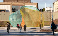 Julkinen värikäs taideteos ja ihmisiä sen edessä.