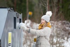 Henkilö laittaa pakkauksen Rinki-ekopisteen säiliöön.