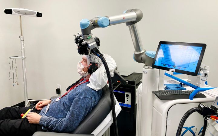 Aivojen sähköisiä vasteita voidaan tutkia mittaamalla aivosähkökäyrää samanaikaisesti aivostimulaation kanssa. Kuvassa robotti pitelee TMS-kelaa.