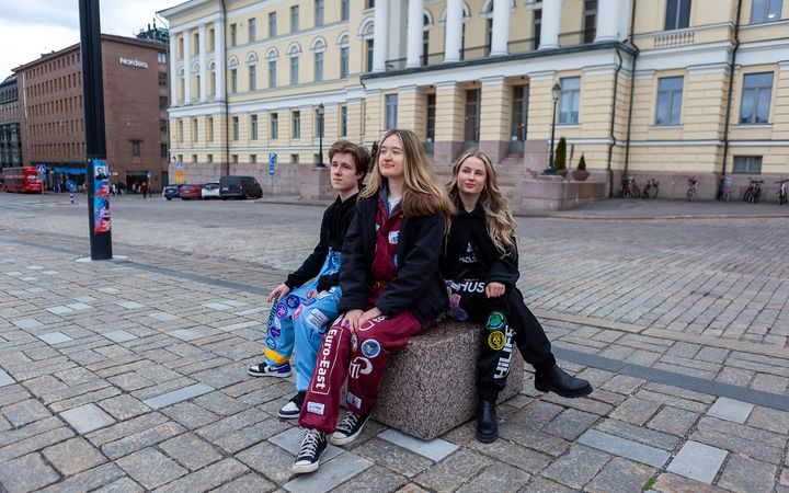 Helsingin yliopiston opiskelijoita haalareihin pukeutuneena päärakennuksen edessä.