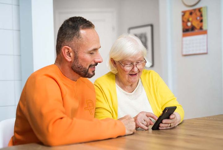 Man and an older woman looking at mobile phone