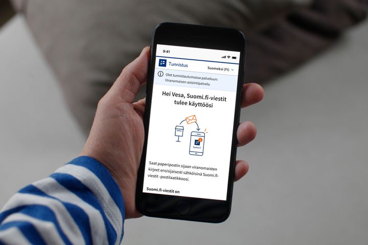 Kuvassa henkilö pitelee kädessään puhelinta ja puhelimen näytöllä on ilmoitus Suomi.fi-viestien käyttööntulosta.