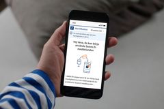 På bilden håller en person en telefon i handen, och på telefonens skärm visas ett meddelande om att Suomi.fi-meddelanden tas i bruk.