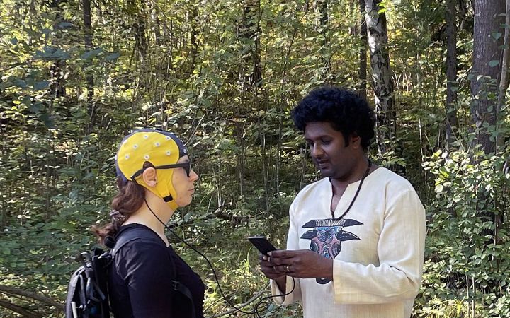 Shrikanth Kulashekhar (kuvassa oikealla) valmistelee tulevaa tutkimusta puistossa. Kuvassa vasemmalla Diana Kulashekhar EEG-myssy päässä.