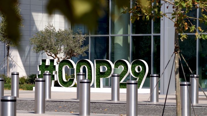 Iso #COP29-kyltti ulkona rakennuksen edessä.