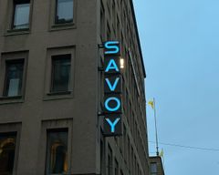 Valomainos Savoy-ravintolasta, jossa A-kirjaimen yhteyteen on lisätty huutomerkki.