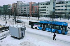 Harmaa mittausasema seisoo kadun varrressa.