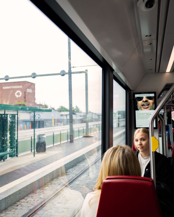 Raitiovaunumatkustajia istumassa