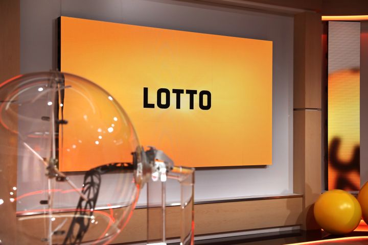 Loton arvontapallot ja taustalla keltainen taulu, jossa lukee "LOTTO".