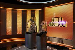 Eurojackpot-arvontastudio, jossa on arvontakoneet valaistussa tilassa.