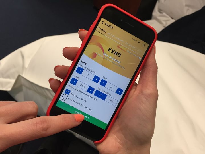 Henkilö tarkastelee Keno-peliruudukkoa puhelimessa.