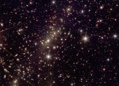 Kuva 3: Euclidin kuva 2,7 miljardin valovuoden päässä sijaitsevasta Abell 2390 -galaksijoukosta. Joukon keskustassa voidaan nähdä kaarevia viirumaisia kohteita, jotka ovat joukon painovoiman synnyttämän gravitaatiolinssin vääristämiä joukon takana olevia galakseja. Gravitaatiolinssejä tutkimalla voidaan saada tietoa galaksijoukkojen sisältämästä pimeän aineen määrästä. Kuva: ESA/Euclid/Euclid Consortium/NASA, image processing by J.-C. Cuillandre (CEA Paris-Saclay), G. Anselmi; CC BY-SA 3.0 IGO or ESA Standard Licence.