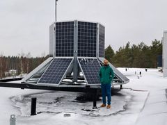 Väitöskirjatutkija seisoo aurinkopaneelikarusellin vieressä, joka osoittaa eri ilmansuuntiin talvisessa maisemassa.