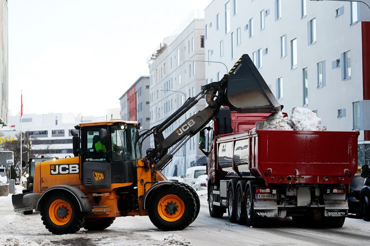 Snön lastas på lastbilsflaket.