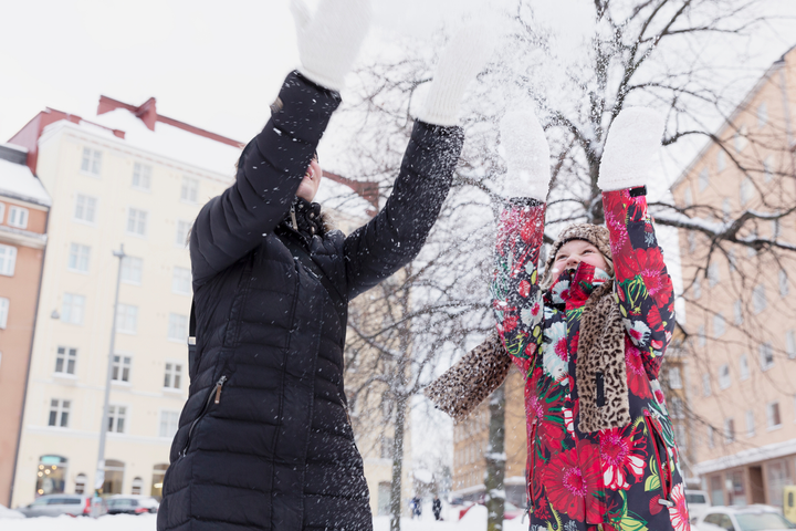 Tytär ja äiti iloitsevat lumisessa säässä Helsingissä