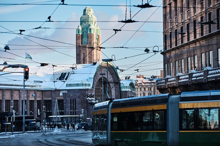 Talvinen kuva, etualalla raitiovaunu, taustalla Rautatieasema.