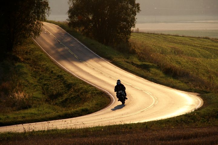 Moottoripyörä maantiellä ajossa.