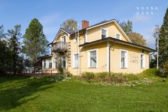 Keltainen kaksikerroksinen puutalo Villa Gerby, iso piha ja nurmikkoa ja puita ympärillä.