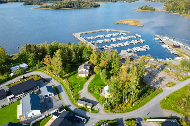 Flygbild över Villa Gerbys tomt och omgivning. Bredvid syns Gerby hamn och bryggområdet fullt av båtar, och på andra sidan bostadshus. Villan omges av ett grönskande landskap.