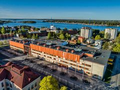 Aerial view of Vaasa University of Applied Sciences campus with buildings and water in the background.