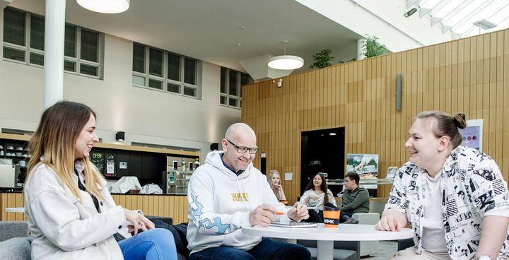 A group of students having a discussion in a modern campus setting.