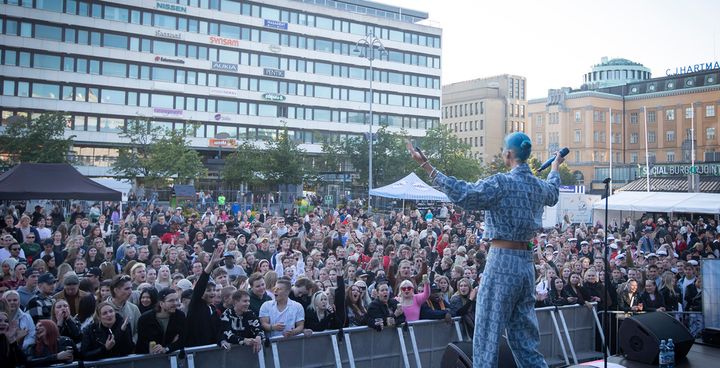 Performer on stage addresses a large crowd at Vaasa Campus Festival.