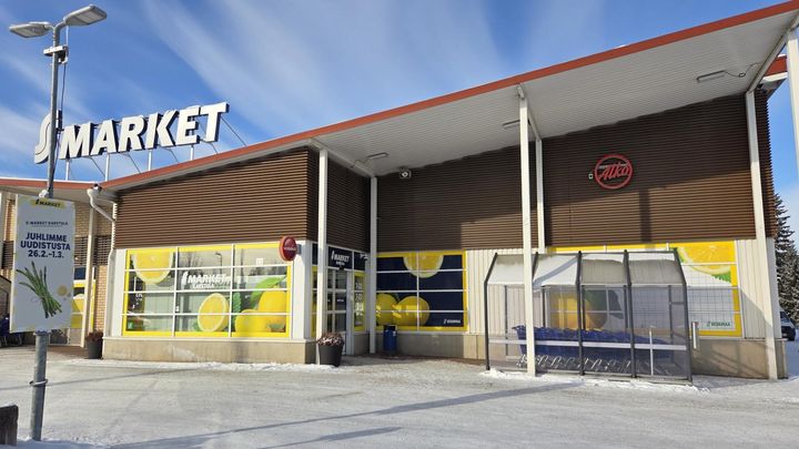 S-market Karstulan julkisivukuva, jossa on suuret sitruunakuvioiset ikkunat ja S Market -kyltti. Maassa on lunta.