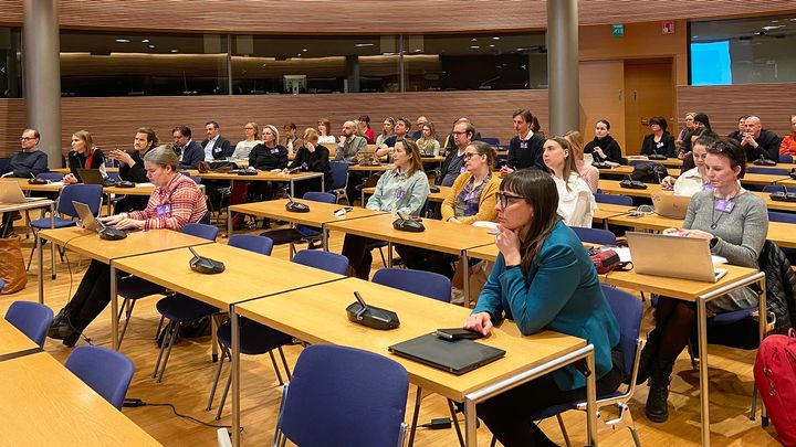 Seminaariosallistujat keskittyvät kuuntelemaan esitystä eduskunnan Pikku-Parlamentin auditoriossa.