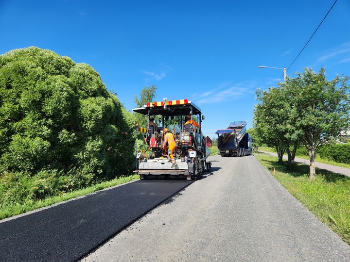 Päällystystä murskeen päälle koneella, taustalla kuorma-auto.