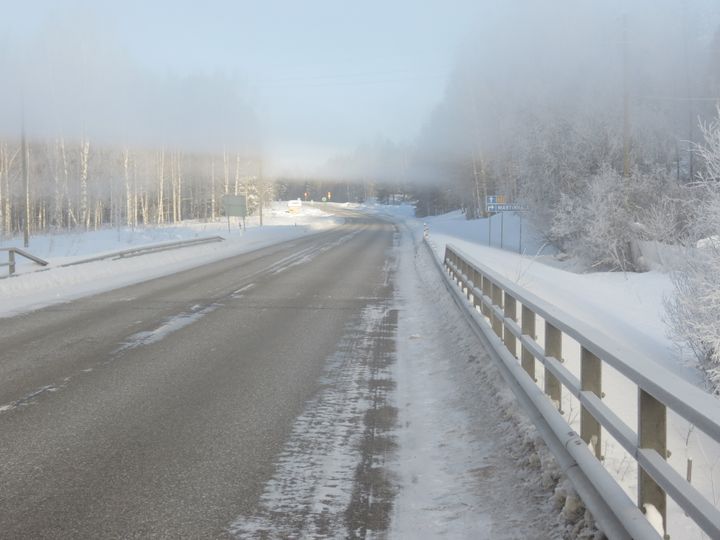 Tyhjä talvinen maatie sillalta kuvattuna.