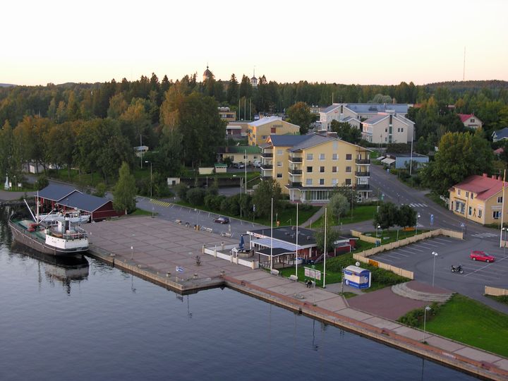 Pieni taajama, jossa on muutamia taloja. Etualalla vesistö ja laiva