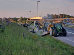 Useita traktoreita tekemässä niittotöitä Kehä III:lla.
