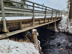 Kylänojan silta talvisessa maisemassa, lumen peittämänä.