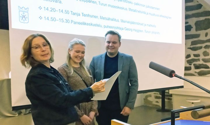 Tiia ja Santeri Kaartovuori-Knaapinen vastaanottivat kulttuuriympäristötekopalkinnon kulttuuriympäristötyöryhmän puheenjohtajalta Paula Saarennolta Turun linnassa pidetyssä seminaarissa.