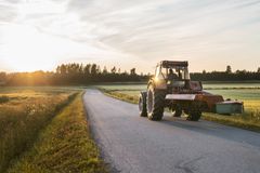 Traktori tiellä ilta-auringossa