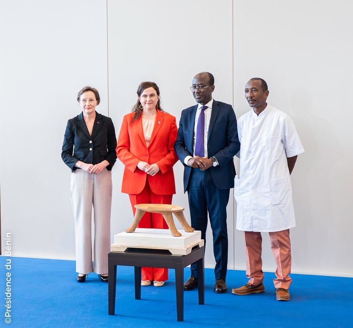 Cotonoussa, Beninissä, sijatsevassa La Marinan palatsissa 13.5.2025 järjestettyyn seremoniaan osallistuivat Suomen kansallismuseon ylijohtaja Elina Anttila (vas.), tiede- ja kulttuuriministeri Mari-Leena Talvitie, Beninin kulttuuriministeri Jean Michel Abimbola ja Beninin museon työntekijä. Suomen kansallismuseon Beninin tasavallalle palauttama kataklè etualalla. Kuva: Présidence du Bénin